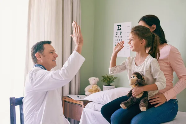 Choca esos cinco para una niña valiente. Inyección de un médico dando a su joven paciente una alta cinco después de su chequeo. —  Fotos de Stock