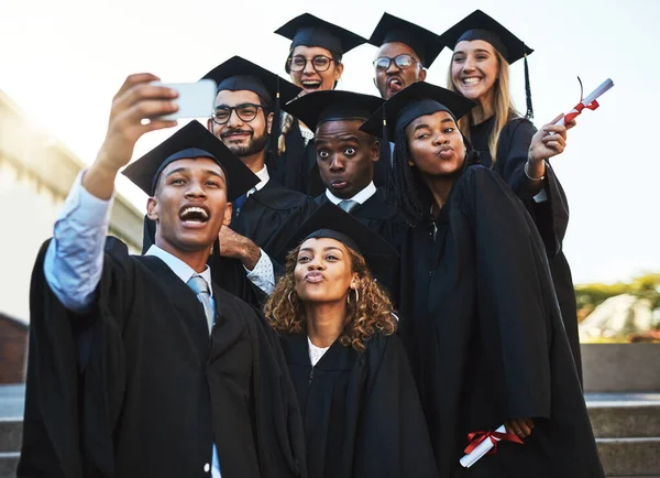 Bueno, nunca olvides este día. Fotografía de un grupo de estudiantes tomando una selfie el día de la graduación. —  Fotos de Stock