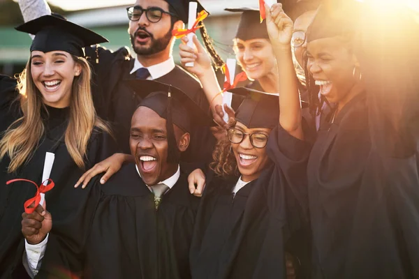 Nuestros padres están muy orgullosos de nosotros. Foto de un grupo de estudiantes universitarios alegres en el día de la graduación. —  Fotos de Stock