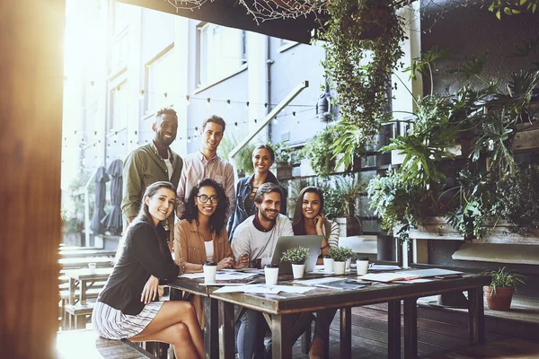 Nous préférons nos réunions dans un cadre détendu. Portrait d'un groupe de collègues en réunion dans un café. — Photo