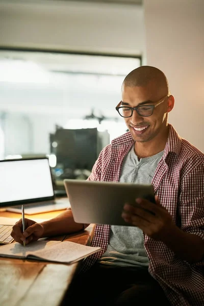 A trabalhar arduamente para chegar ao topo. Tiro recortado de um jovem designer trabalhando tarde em um escritório. — Fotografia de Stock