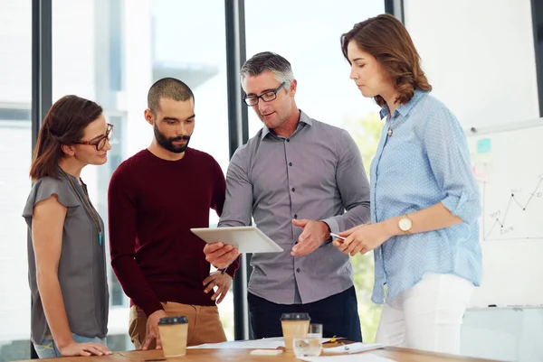 Collabora, connetti e crea. Foto di un gruppo di uomini d'affari che discutono di qualcosa su un tablet digitale. — Foto Stock