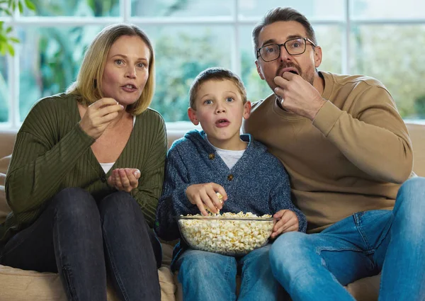 Le serate cinematografiche sono le nostre preferite. Girato di una famiglia che si gode una ciotola di popcorn mentre guarda un film. — Foto Stock