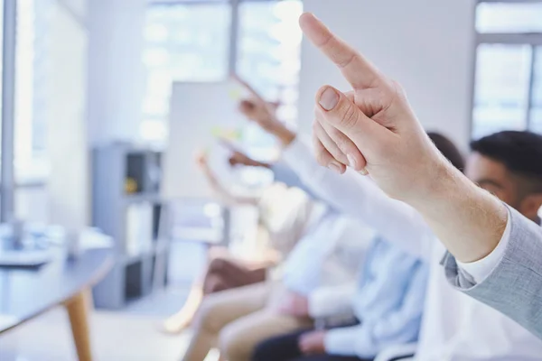Tenemos preguntas. Recorte de un grupo de empresarios levantando la mano durante una reunión. — Foto de Stock