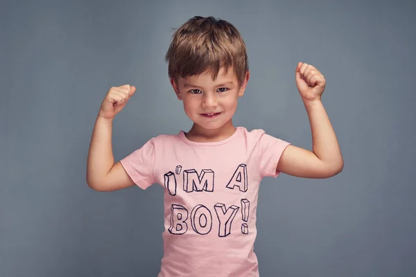 I duri vestono di rosa. Studio ritratto di un ragazzo allegro che indossa una camicia con Im un ragazzo stampato su di esso su uno sfondo grigio. — Foto Stock