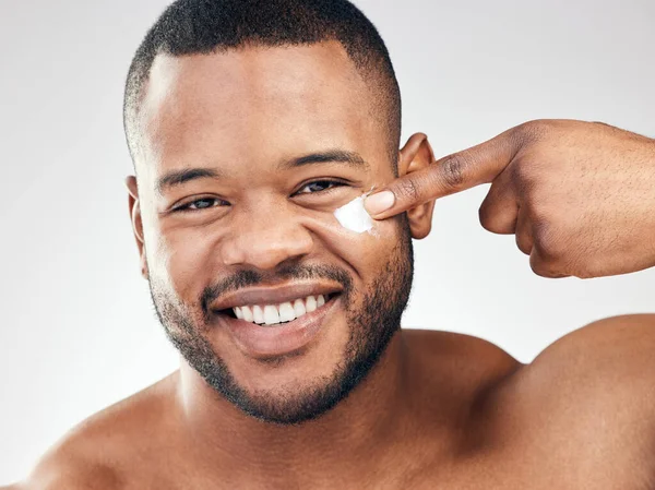 Estúdio Retrato Jovem Bonito Aplicando Hidratante Seu Rosto Contra Fundo — Fotografia de Stock