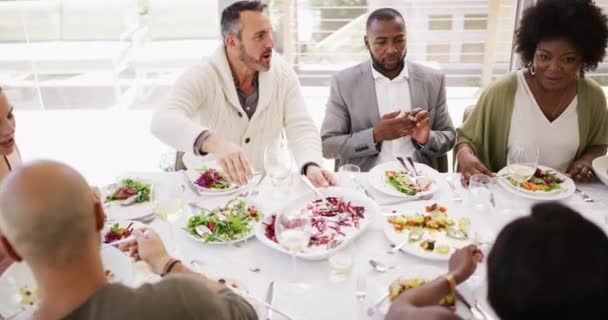 多样化的 成熟的朋友圈 在家里或餐馆吃饭 同事们一边吃东西一边笑着 一边一起举杯 — 图库视频影像