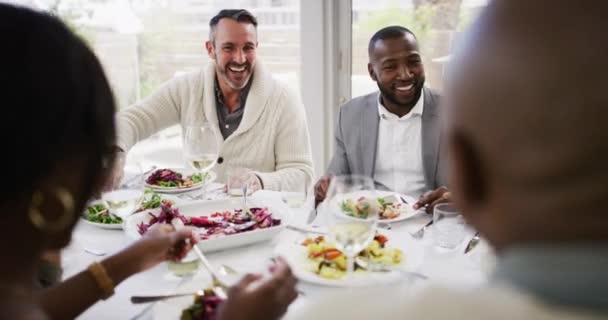 不同的人群一起吃着节日大餐 微笑的朋友们坐在一起 举杯敬酒 享用美味的午餐 男人和女人享受和感到快乐和社交 — 图库视频影像