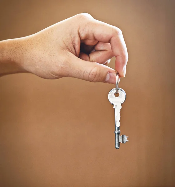 Cropped shot of an unrecognizable mans hand holding the key to his new home.