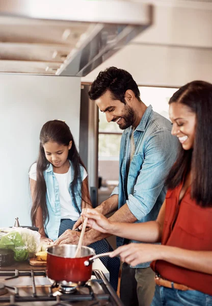 拍了一个快乐的年轻家庭一起在厨房做饭在家里 — 图库照片
