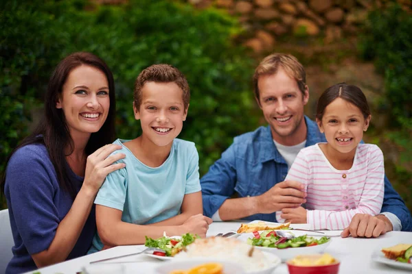 パティオで食事を楽しむ笑顔の家族の肖像画 — ストック写真