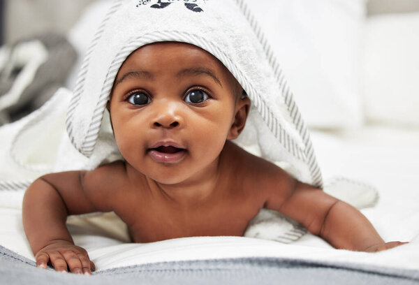 Shot of an adorable baby boy wearing a hoody towel.