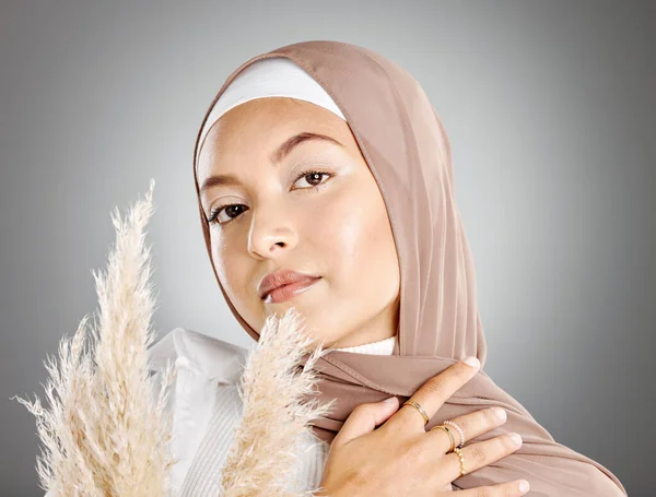 一个年轻美丽的穆斯林女子头戴褐色头巾 头戴灰色背景的潘帕斯麦草的工作室肖像 头戴传统头巾的略带阿拉伯穆斯林化了妆 — 图库照片
