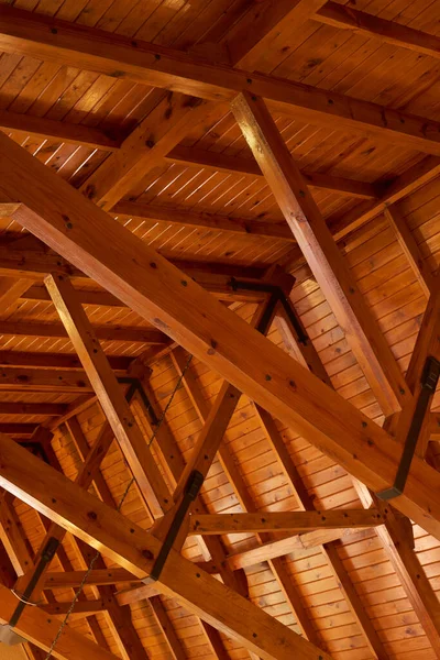 Beautiful sturdy wood architecture of interior roof or ceiling inside a house or building. Wooden beams and natural building material used for interior. Stained wood used for room ceiling feature.