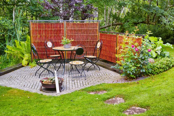 春天或夏天 在美丽的花园或植物区里的椅子和桌子 后院的户外家具 绿树成荫 花朵繁茂 一个和平 宁静和私密的家 — 图库照片