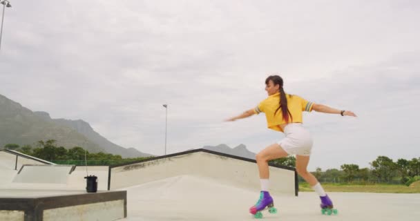 1つの陽気な女性ローラースケートダンスやスケートパークリンクの外で回転 趣味を楽しみながら 自由で精力的にトリックを実行する楽しさを持つトレンディーでクールな楽しい都市スケーター — ストック動画