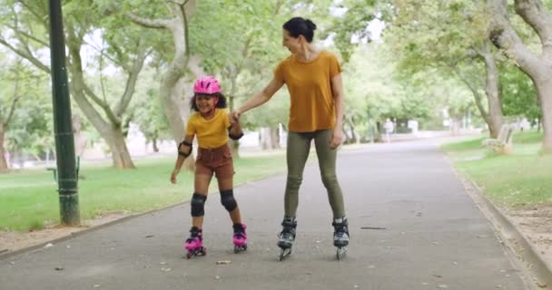 シングルマザーは 公園で彼女の養女とスケート 若い笑顔の親は彼女の愛らしい女の子と自由な時間を楽しんでいます 外ローラースケート 幸せなかわいい子供を身に着けているヘルメットと女性との結合 — ストック動画