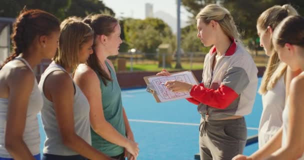 曲棍球教练和一群少年选手在运动场上计划着一个策略 训练者在赛前制定比赛计划 以鼓励和激励高中女子曲棍球队 — 图库视频影像