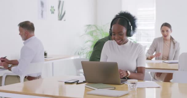 在办公室里和同事一起工作 戴着耳机听音乐的女商人 创业者在一家初创公司的办公桌前计划创意的同时浏览互联网 — 图库视频影像