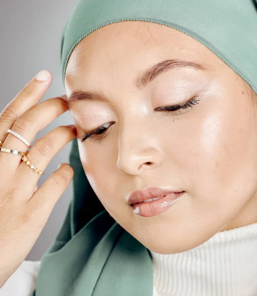 一个发光的美丽的穆斯林女人的衣服在灰色的工作室背景下被隔离 年轻女子戴头巾或头巾 展示她的睫毛和珠宝 触摸完美无缺的皮肤 — 图库照片