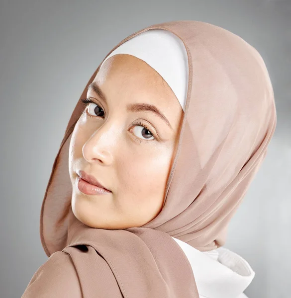 Portrait of hijab wearing traditional muslim woman in arabic style in studio. Headshot of proud cultural arab with beautiful skin against grey background. Elegant fashionable oriental middle eastern.