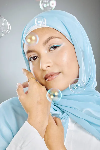 泡と灰色の背景に青いスカーフを身に着けている1つの美しい若いイスラム教徒の女性のスタジオの肖像画 ハッピーアラブ女性身に着けている化粧で顔カバーでヒジャーブのために伝統的な謙虚さ — ストック写真
