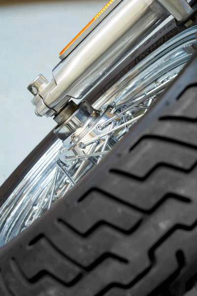 A tilted front view of motorbike tire, High-performance all-season tires designed for a modern sports bike. Suspension of modern motorcycles front wheel. Front-wheel shock absorber and reflector