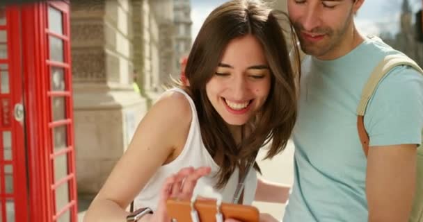 Ein Fröhliches Junges Paar Blickt Auf Sein Smartphone Und Lacht — Stockvideo