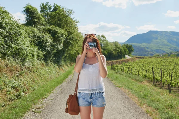 休暇中の女性だけで彼女のデジタルカメラで田舎の写真を撮る ブドウ畑の隣の女性がデジタルカメラで写真を撮る 休暇中に田舎に写真を撮る女性 — ストック写真