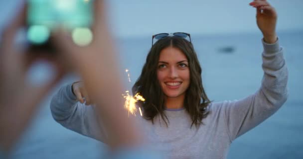 Przyjaciele Bawią Się Plaży Ogniem Kobieta Robiąca Zdjęcie Przyjaciółce Smartfonem — Wideo stockowe