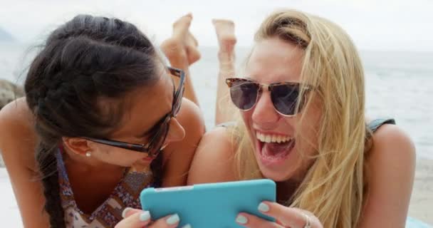 两名女性放松享受暑假智能电话科技海滩 — 图库视频影像