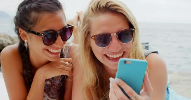 两名女性放松享受暑假智能电话科技海滩 — 图库视频影像