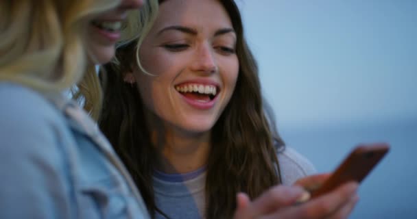 Fröhliche Freunde Die Beim Anblick Eines Mobiltelefons Lachen Und Reden — Stockvideo