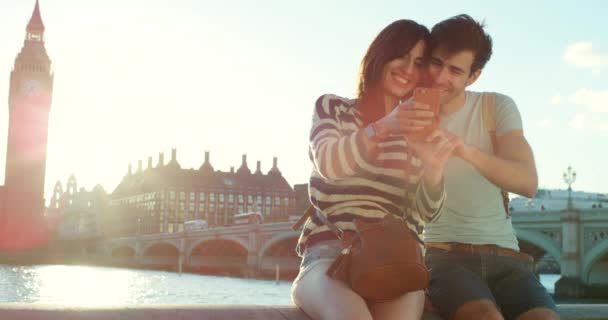 一对快乐的夫妇在伦敦度假时看手机 — 图库视频影像