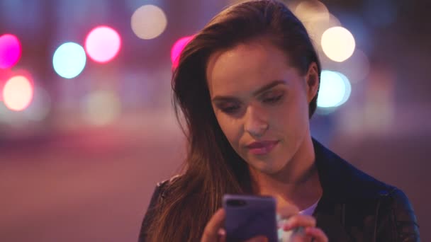 Μια Νεαρή Γυναίκα Έξω Στην Πόλη Νύχτα Χρησιμοποιεί Κινητό Της — Αρχείο Βίντεο