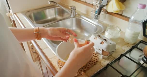 Een Vrouw Die Eieren Breekt Een Kom Pannenkoekenbeslag Maken Ontbijt — Stockvideo