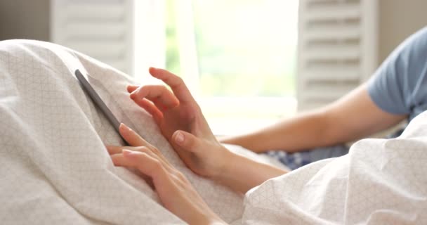 Ένα Ζευγάρι Που Κάθεται Στο Κρεβάτι Χρησιμοποιώντας Ψηφιακό Tablet Τους — Αρχείο Βίντεο