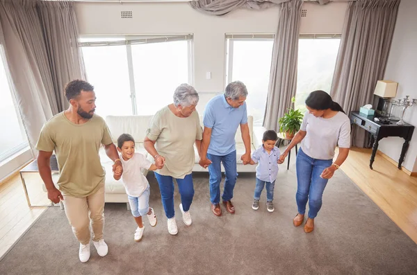 Mixed race family having fun and dancing in the living room at home. Little boys and grandparents having a fun day at home with their parents. Having dance battle with fun family.