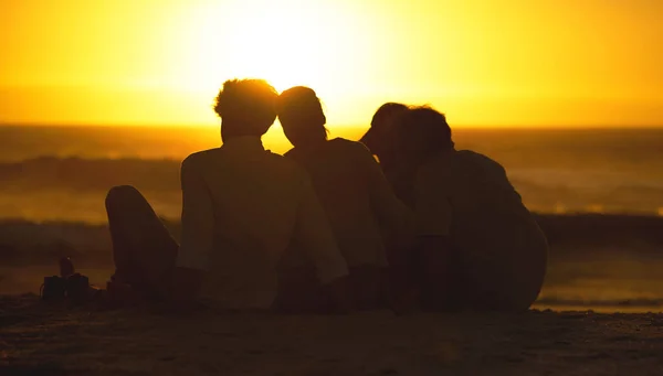 在一个享受大海美景的家庭后面 一个家庭坐在海滩上的轮廓 一家人在海滩上欣赏日落 家人在海滩上相亲相爱 — 图库照片