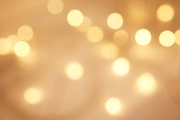 Abstract blurry twinkled lights background with bokeh defocused yellow lights. Closeup blurred glittery sparkly lights. Closeup blurry candle lights at an evening celebration.