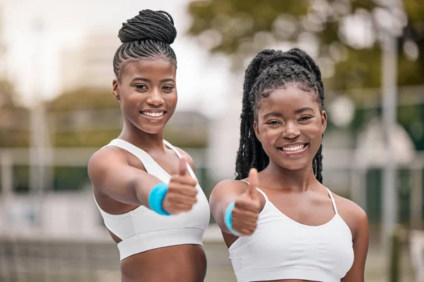 Portrait of african american tennis players with a thumbs up. Happy friends support each other before tennis practice. Young tennis players celebrate their success after a match.