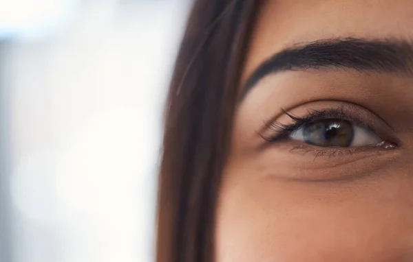 Closeup portrait of a mixed race unrecognizable woman eye with perfect eyebrows and natural looking eyelash extensions while at home on the weekend.