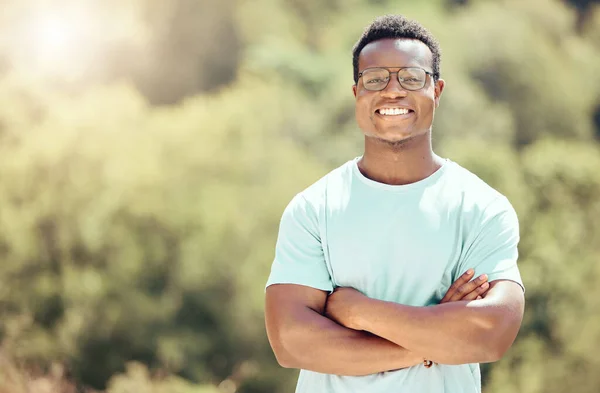 一位年轻英俊的非洲裔美国男子戴着眼镜 双臂交叉地站在外面 快乐而自信的黑人男人一边微笑着一边在大自然中度过一天 我喜欢夏天 — 图库照片
