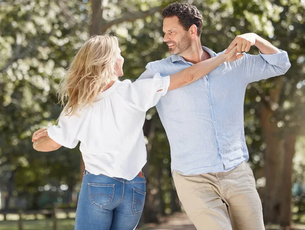 Loving young couple having romantic moment while sharing a dance and spending together in the backyard. Happy caucasian lovers being playful and enjoying time outdoors in a garden.