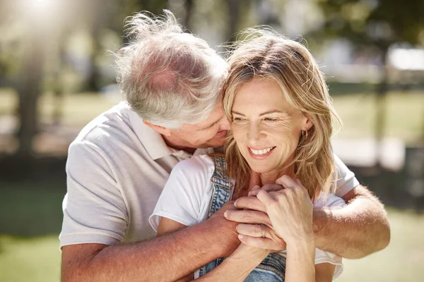 Closeup of an attractive young woman and her father outdoors. Young caucasian female and her senior father bonding outside in the garden on a sunny day.