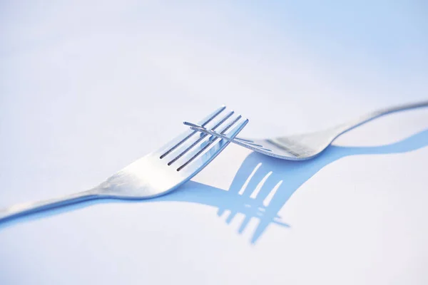 Two forks joined together symbolising togetherness, dependance and unity. This is a symbol of teamwork, relationship and partnership issues and troubles, or dependencies between countries or companies