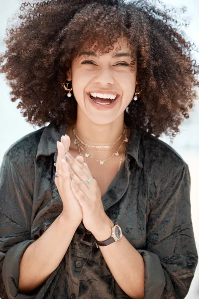 Portrait of a young beautiful mixed race woman with natural curly afro hair style smiling and laughing outside. Young hispanic female expressing joy and confidence with her radiant smile.A beautiful