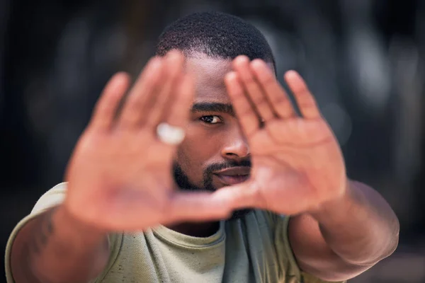 ハンサムな若いトレンディーなアフリカ系アメリカ人の男が 2本の手を使って顔をフレームにして 街の写真を撮りました ダウンタウンの人権に抗議して手を挙げている真剣な黒人男性 — ストック写真