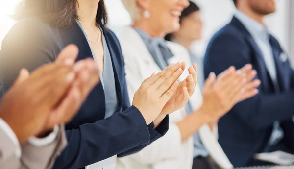 Happy businesswoman clapping hands for presentation during a meeting in an office boardroom with colleagues. Diverse group of businesspeople sitting in a row on a panel as audience and applauding