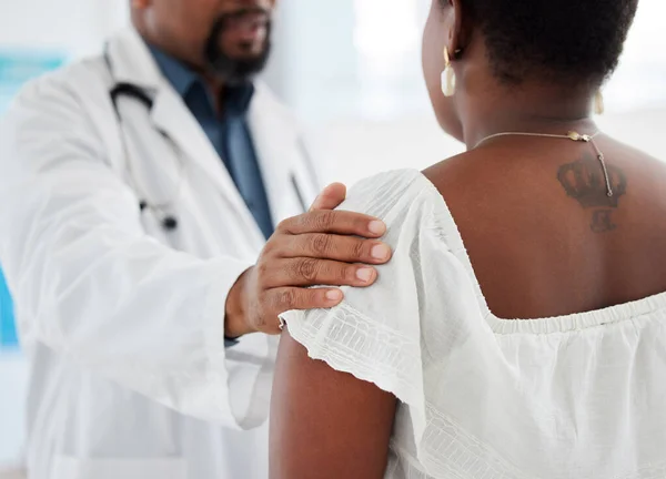 Doctor touching a patient on the shoulder in support. Closeup on hand of doctor being kind to a patient in a checkup. Medical gp offering a patient comfort during a consult cropped